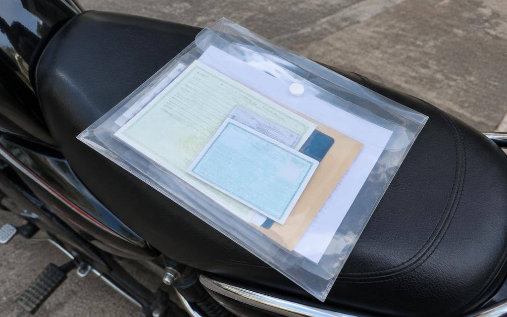 Documento de moto e capacete sobre uma mesa